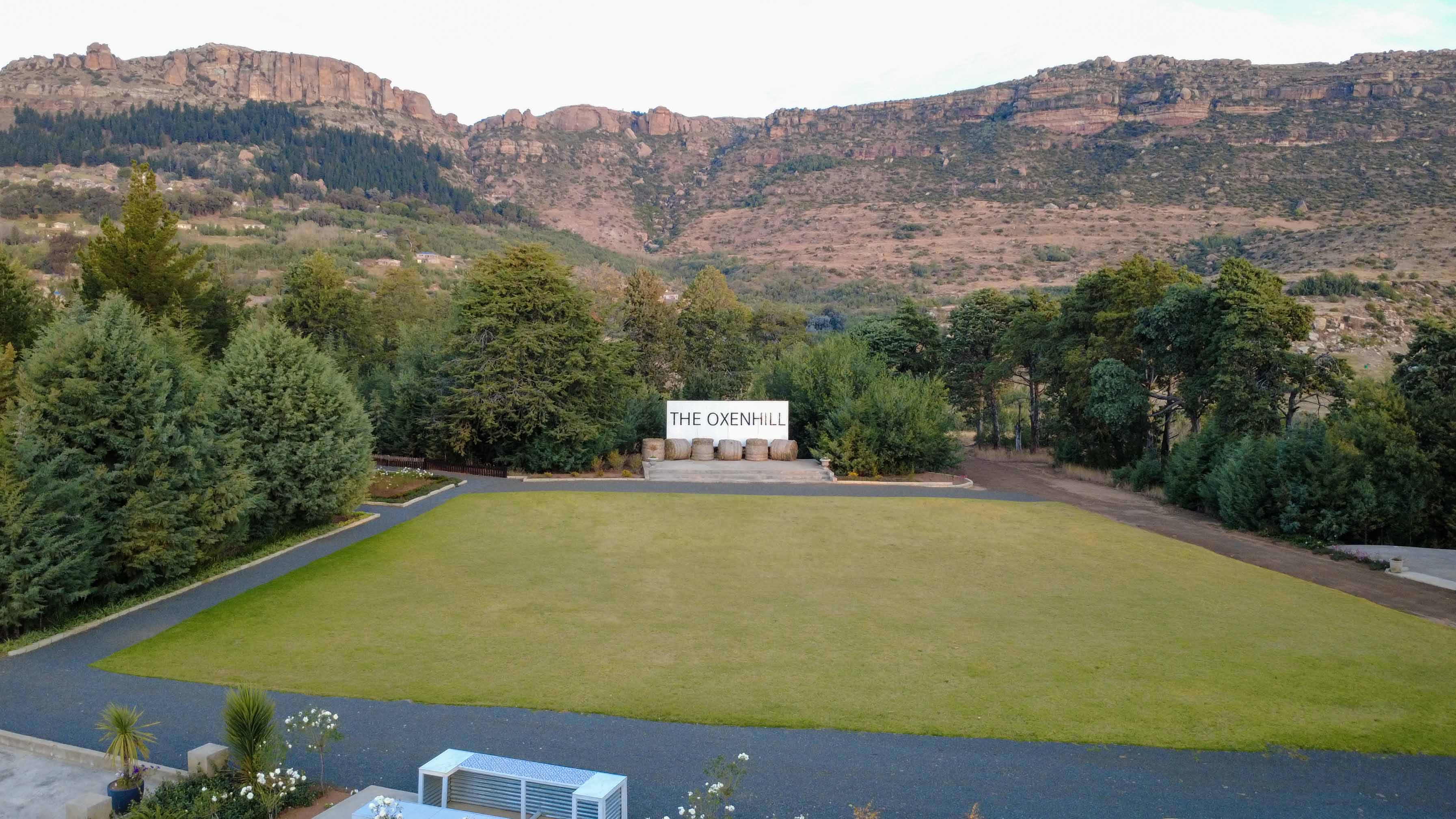 The open lawn surrounded by gardens and cliffs